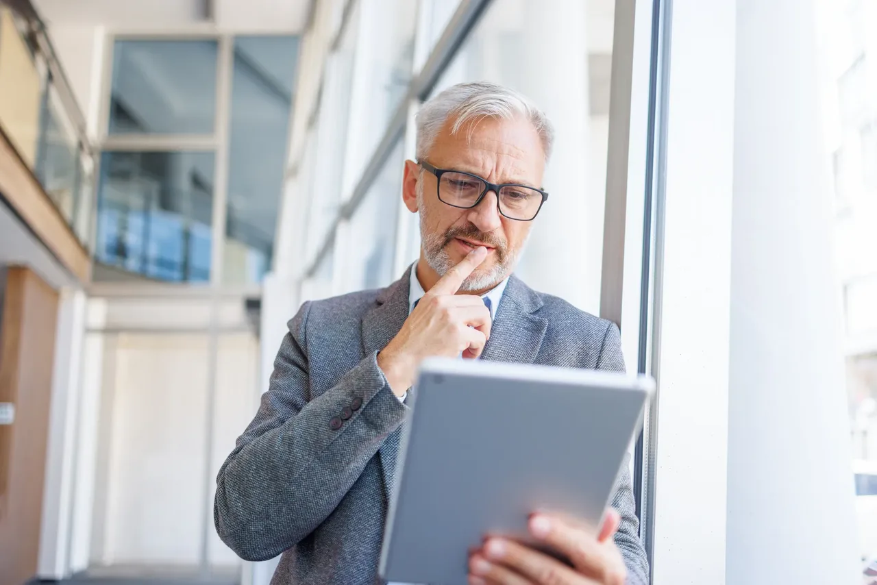 A businessman reviewing a document while assessing security risks