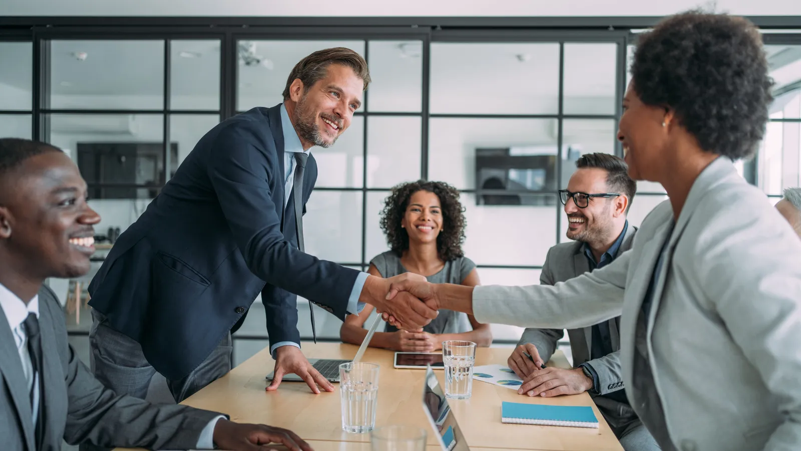 A handshake in a boardroom representing an acquisition