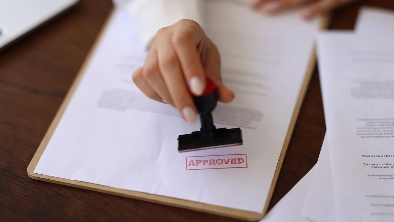 woman applying approved stamp on document