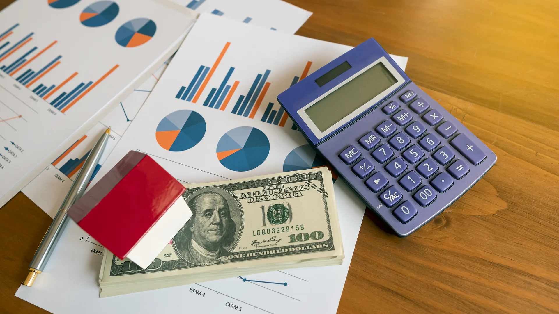 On the table of a businessman with a small house and a dollar with a calculator and graph