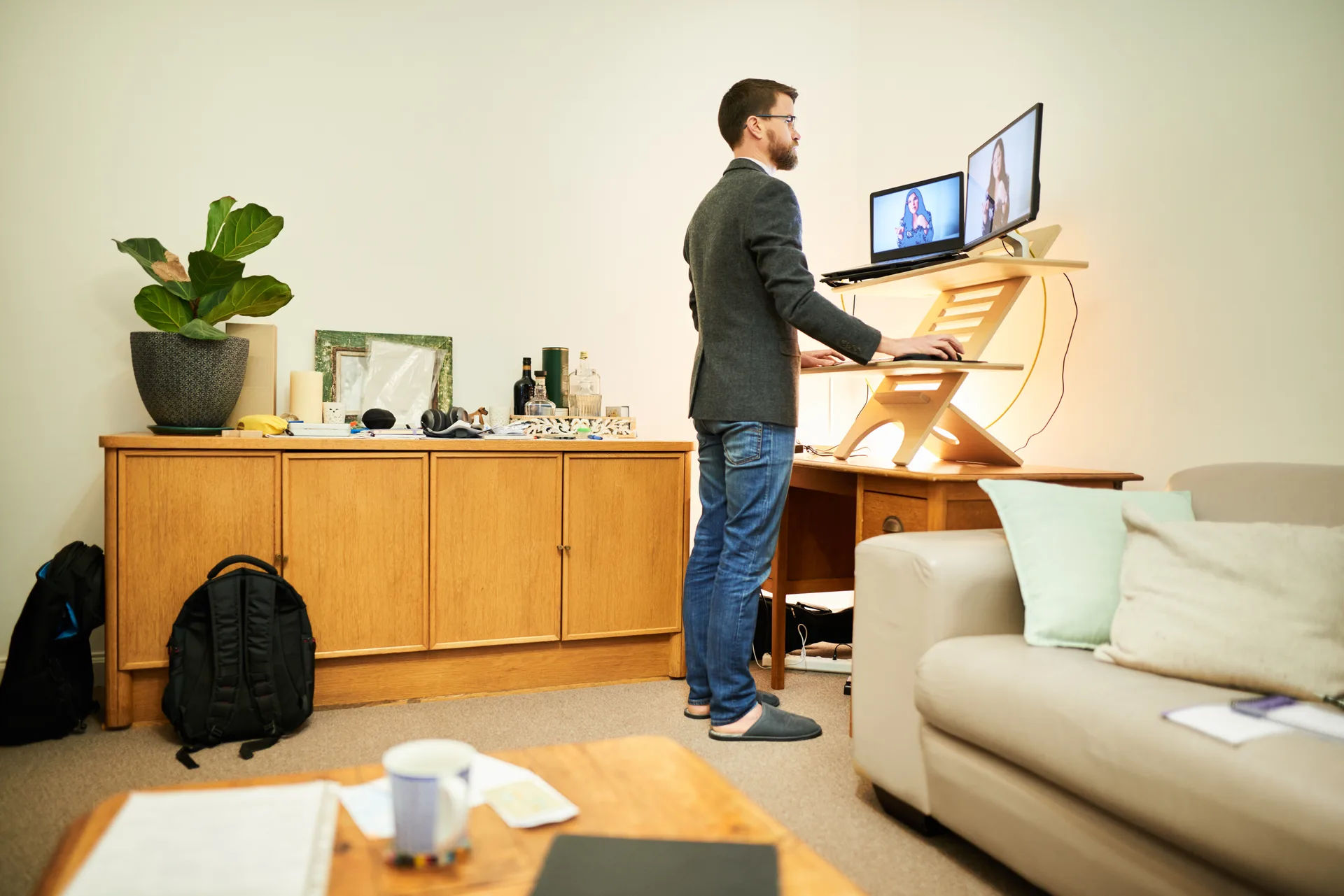 Young man working remotely at a standing desk in his living room