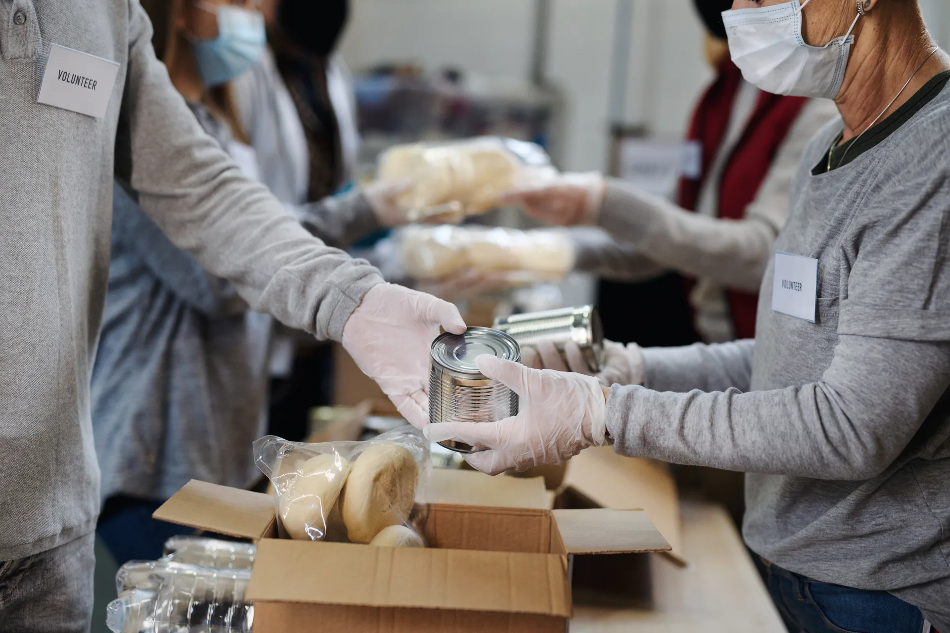 Group of volunteers in community donation center, food bank and coronavirus concept