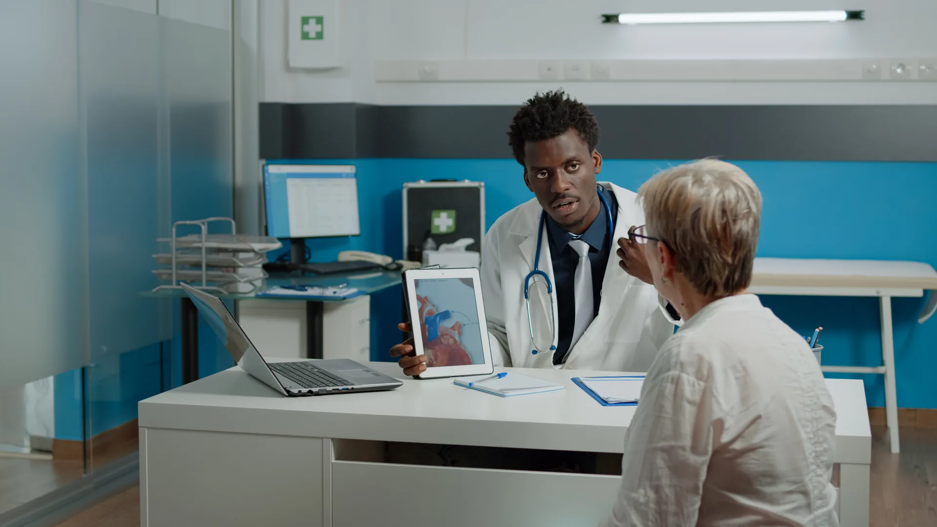 Healthcare specialist explaining cardiogram on tablet display
