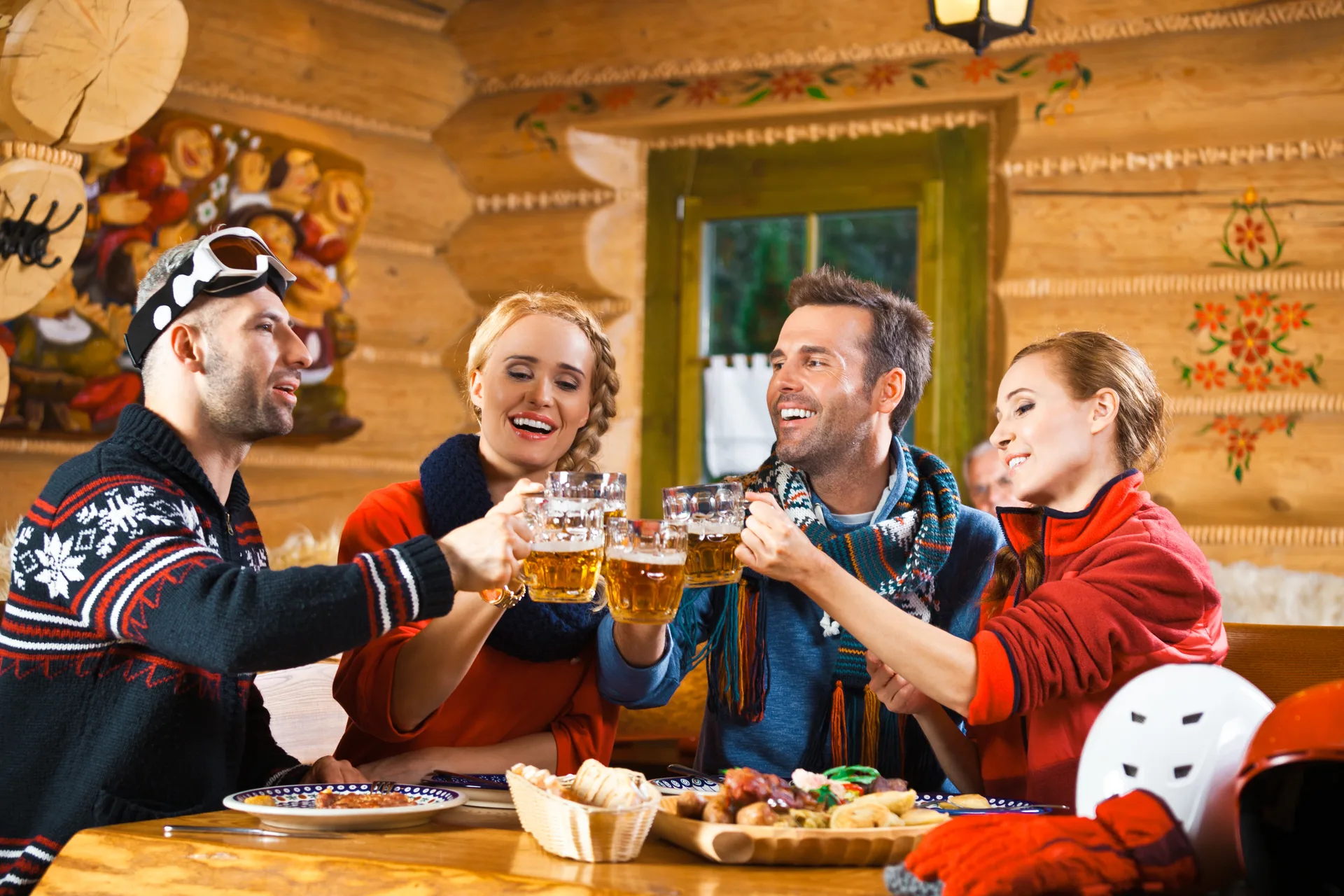 Friends having dinner in restaurant, toasting with beer