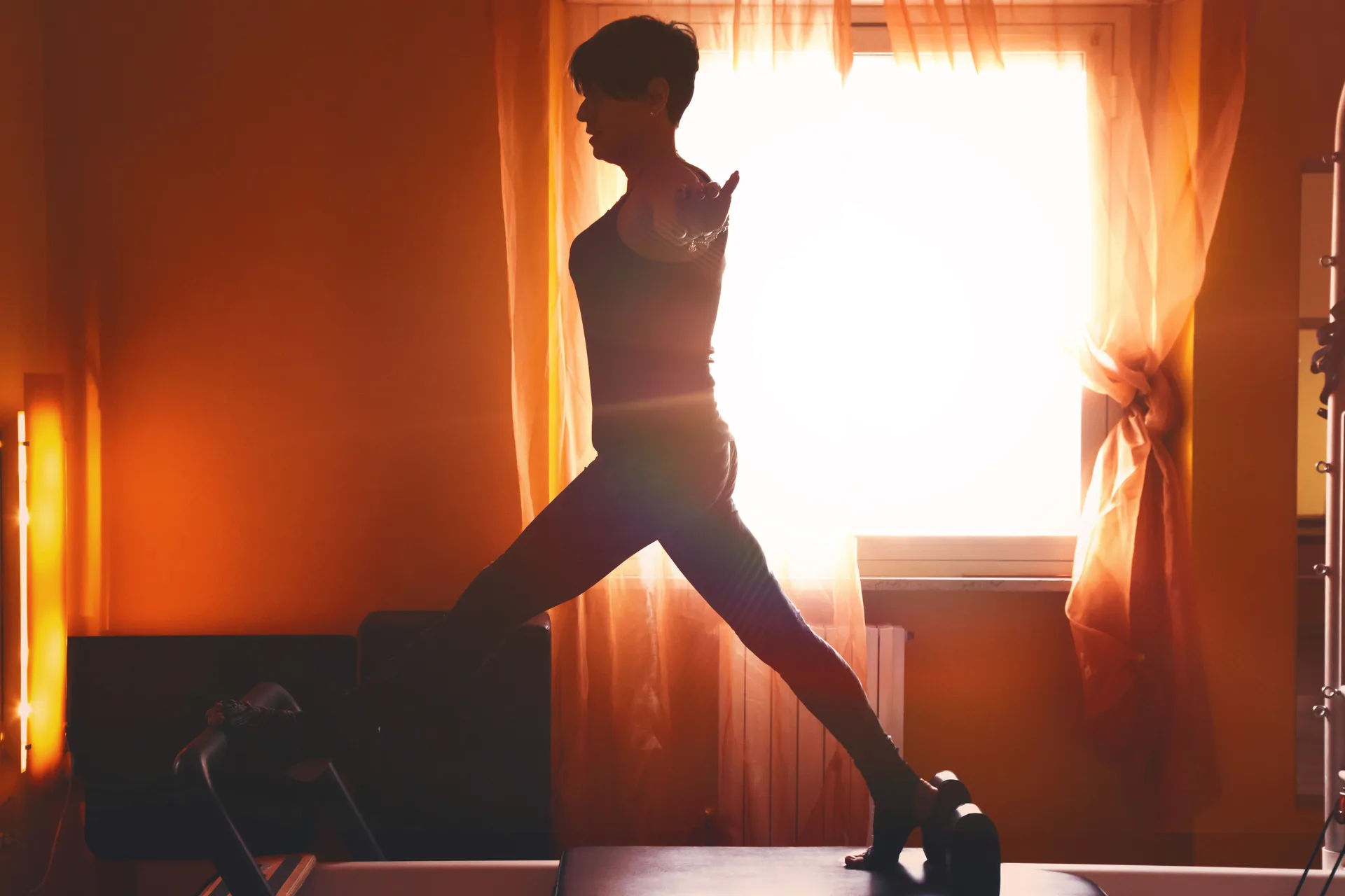 Mature women performing pilates at gym